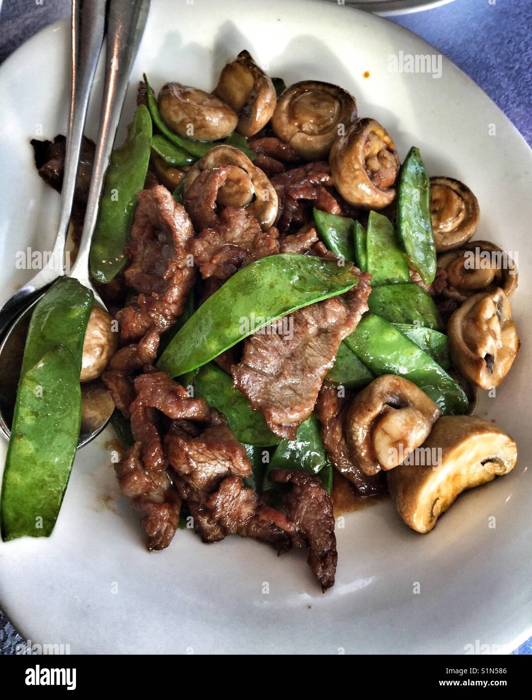Snow peas, mushrooms and beef stir fry Stock Photo Alamy