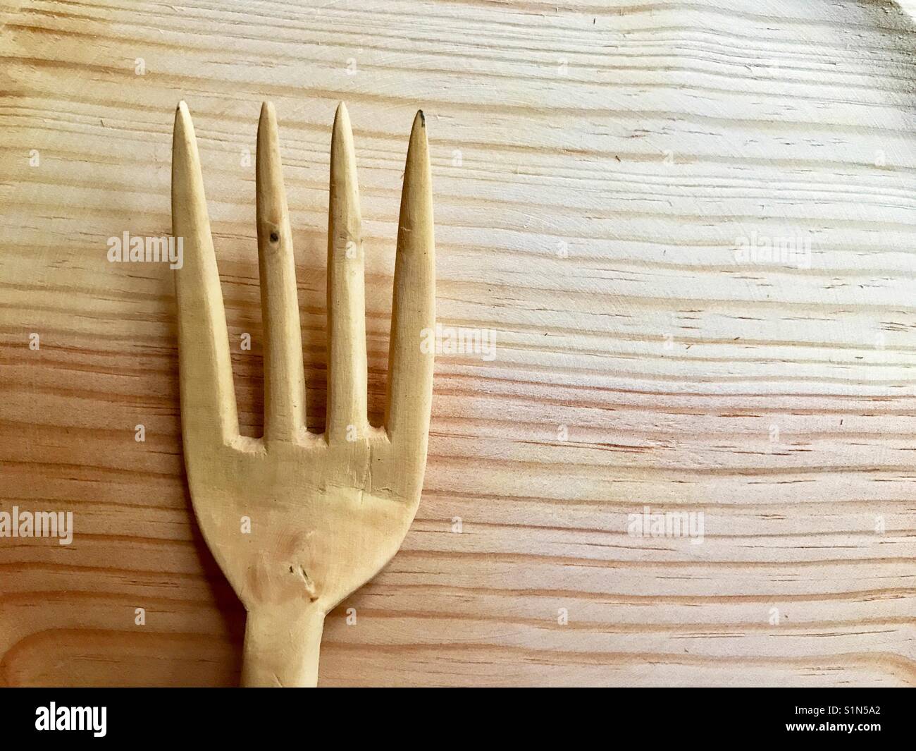 Wooden fork on wood surface. - Smartphone Captured Stock Image