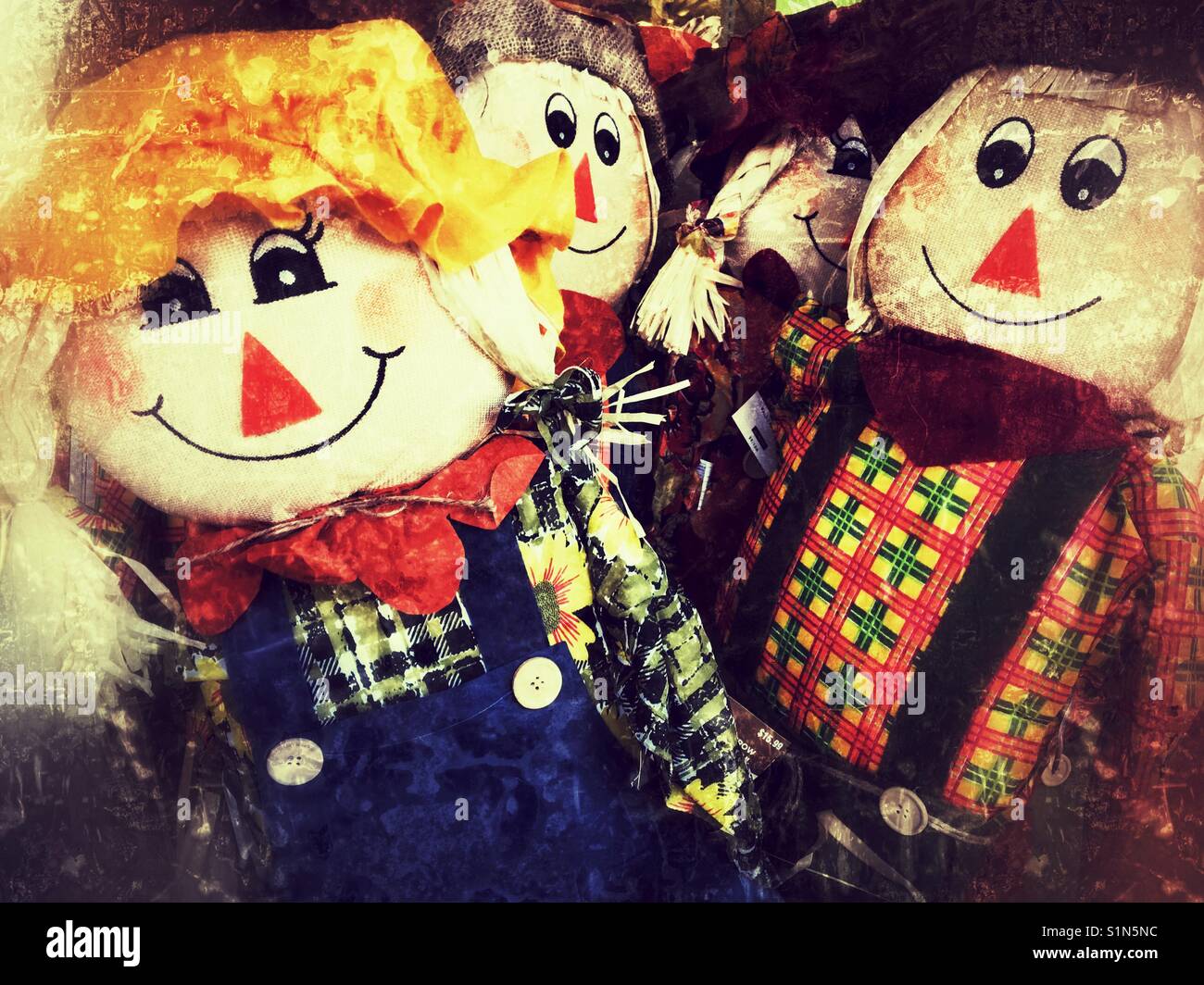 Mass produced smiling scare crow decoration dolls. Stock Photo