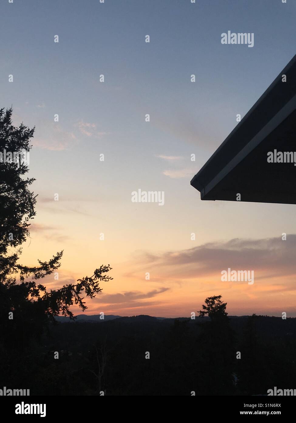 Sunset with roof and trees Stock Photo Alamy