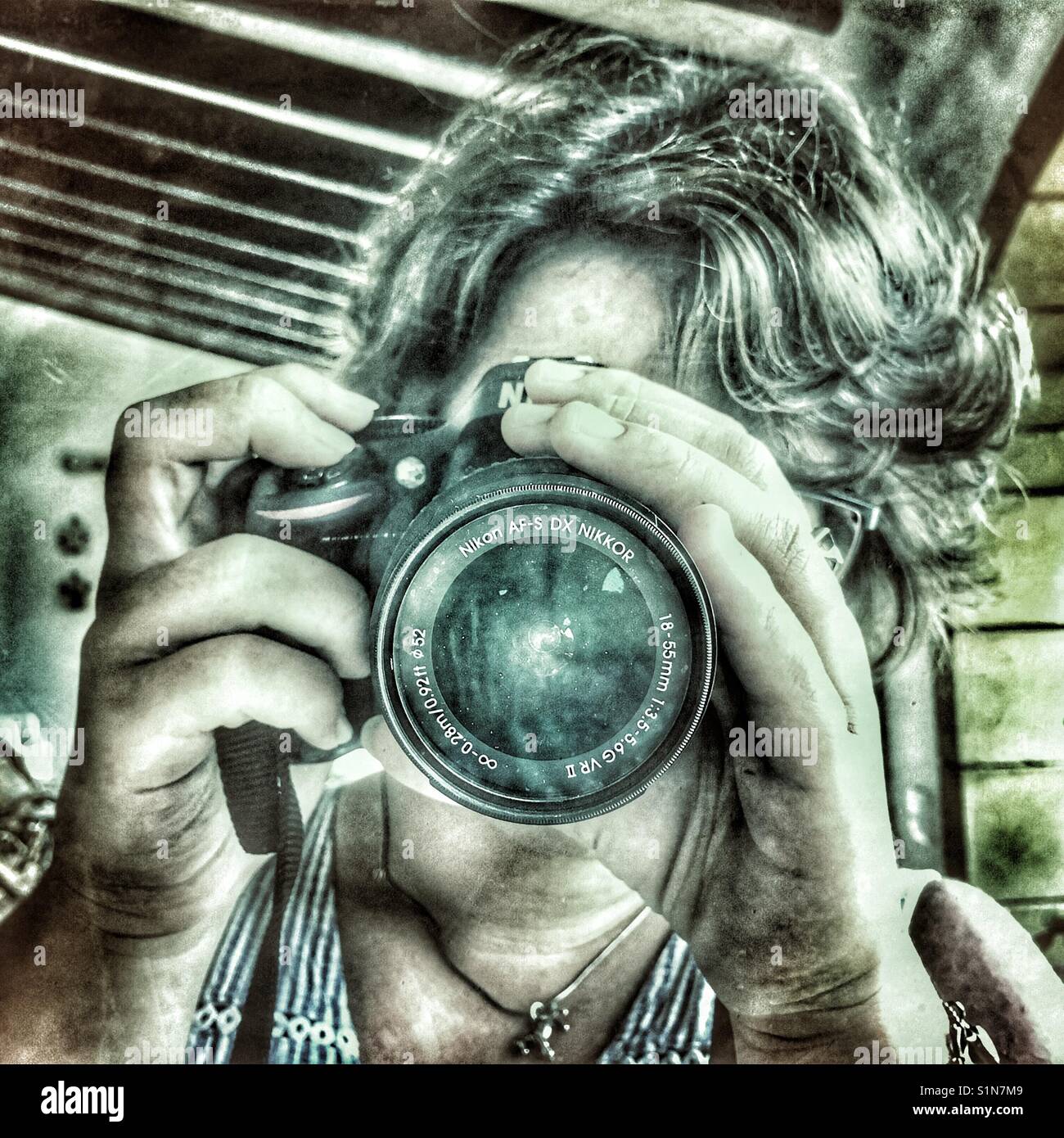 Young woman taking a photograph on. Nikon camera - Smartphone Captured Stock Image