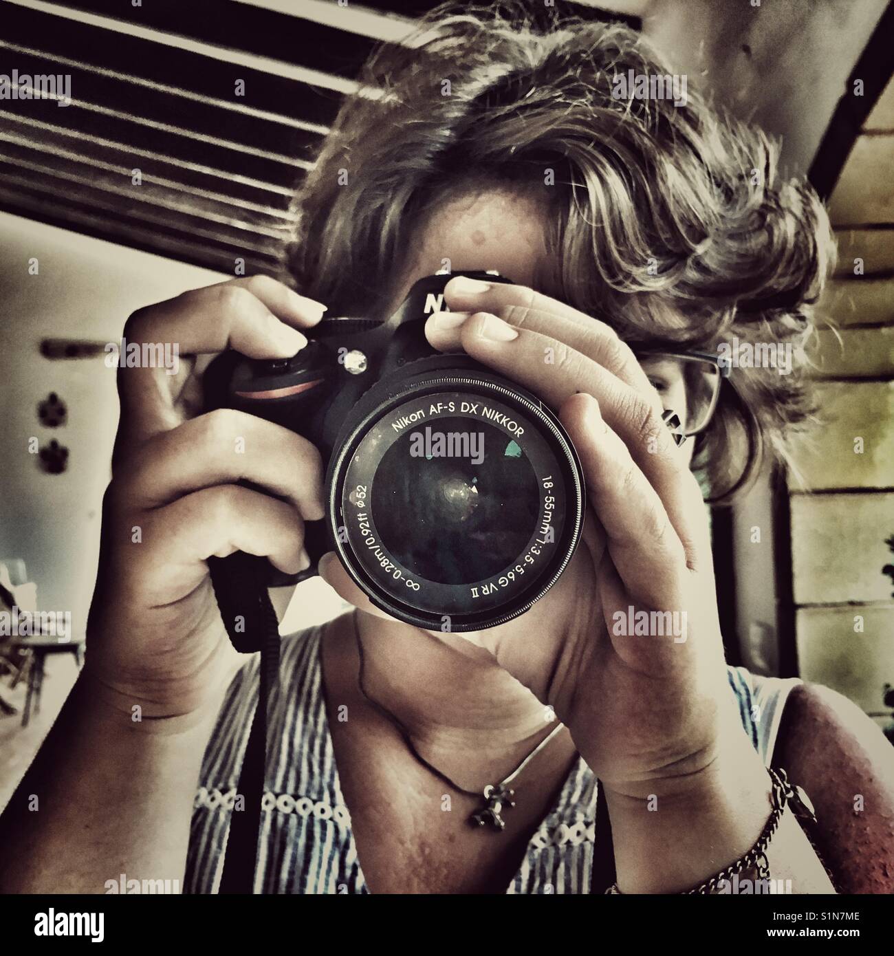 Young woman taking a photograph on. Nikon camera - Smartphone Captured Stock Image