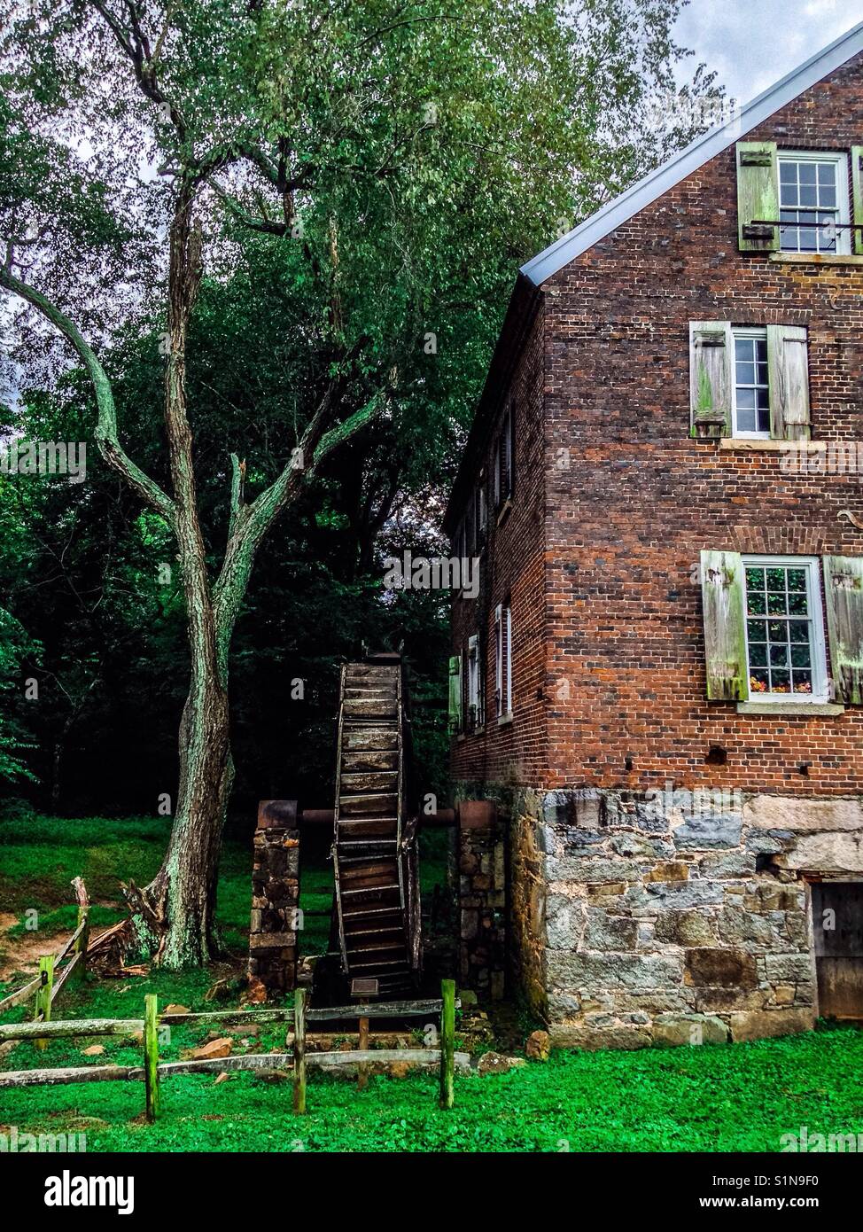 Historic Kerr Mill in Sloan Park at Millbridge North Carolina with water wheel and tree - Smartphone Captured Stock Image