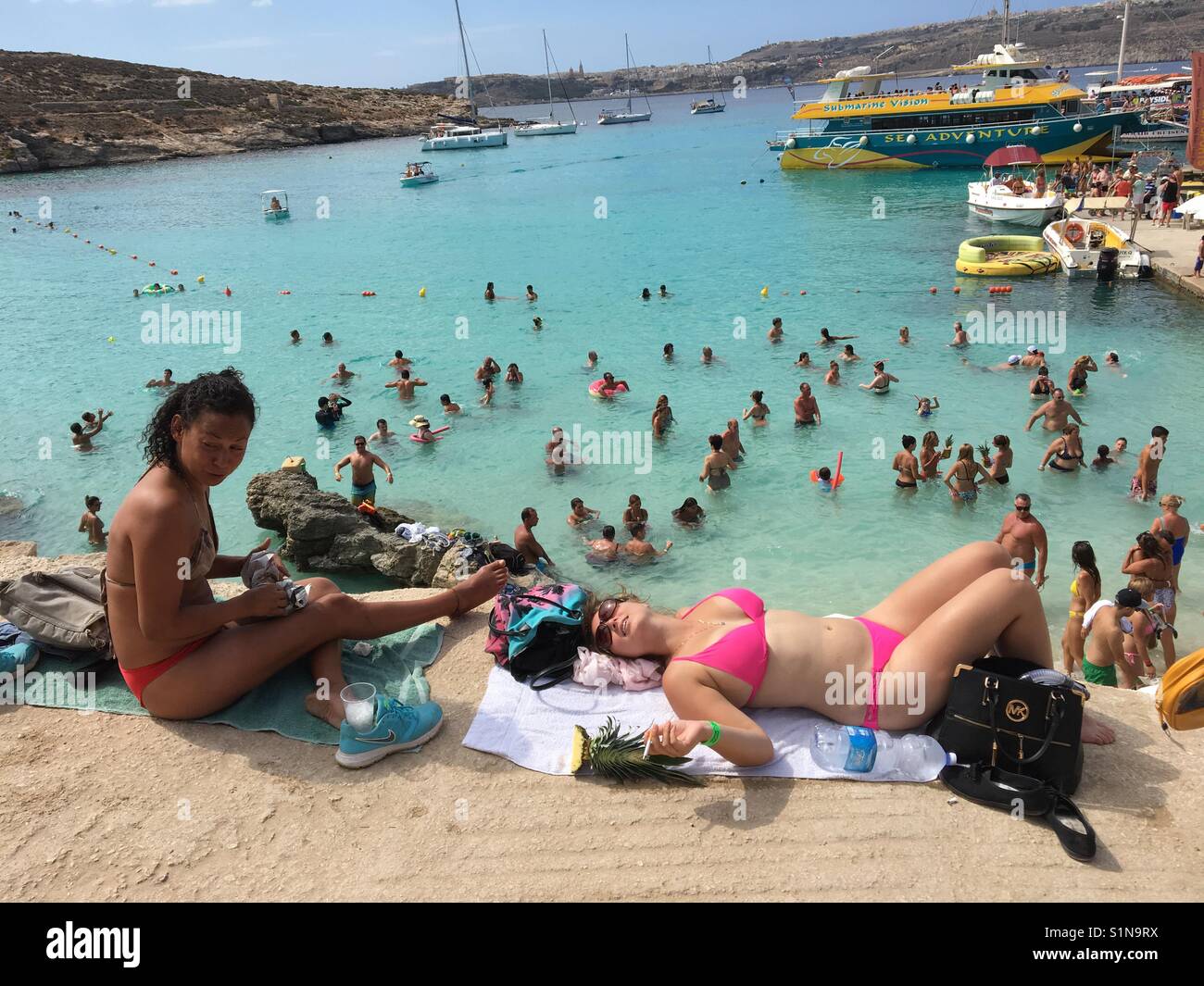 Sunbathers and swimmers at Blue Lagoon on Comino, Malta - Smartphone Captured Stock Image