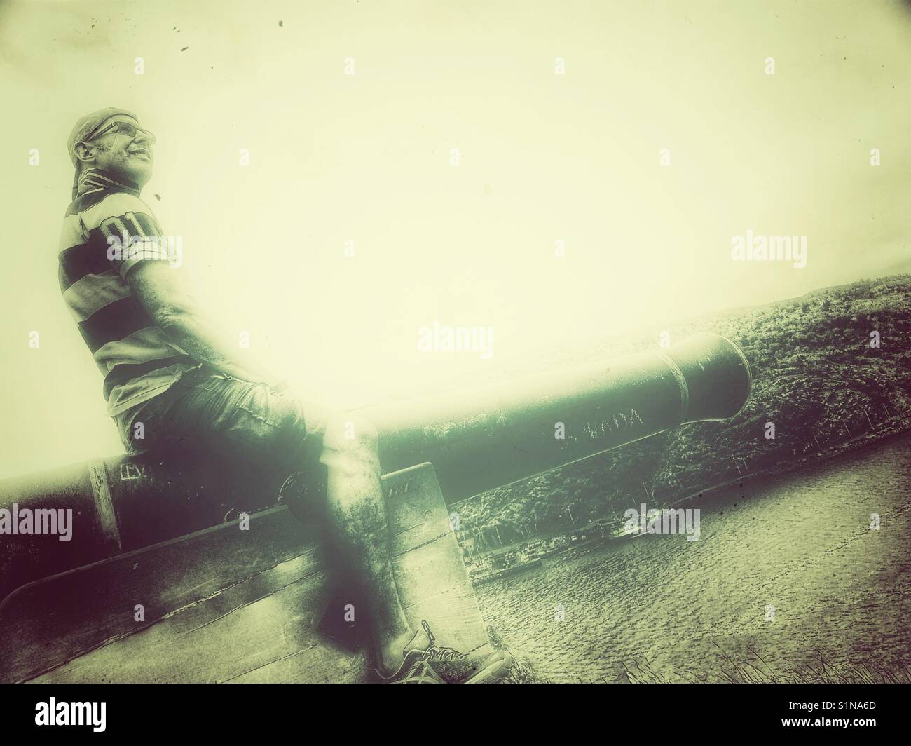 Middle aged Scandinavian man posing on cannon - Smartphone Captured Stock Image