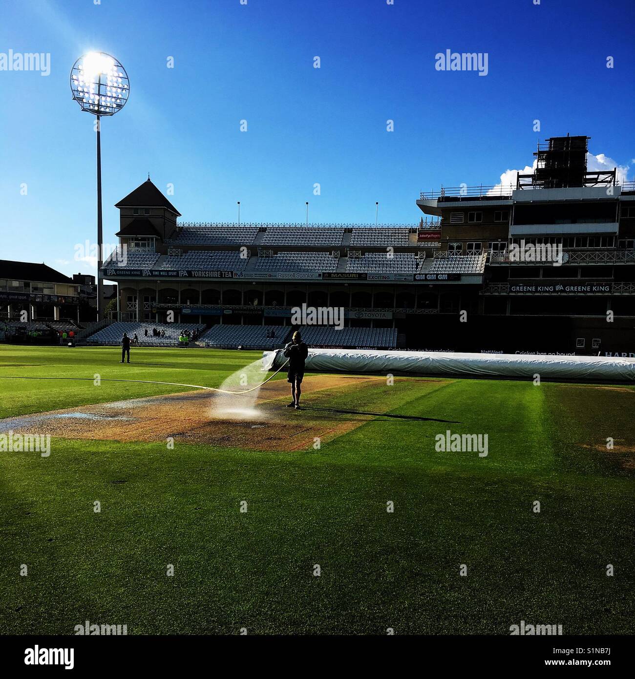 Groundsman at Trent Bridge Nottingham watering the pitch at the end of the days play Stock Photo