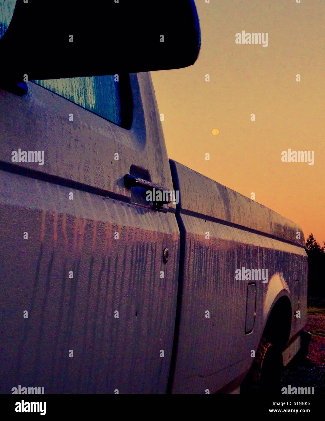 Full moon at dawn framed by pickup wet with dew in North Carolina - Smartphone Captured Stock Image