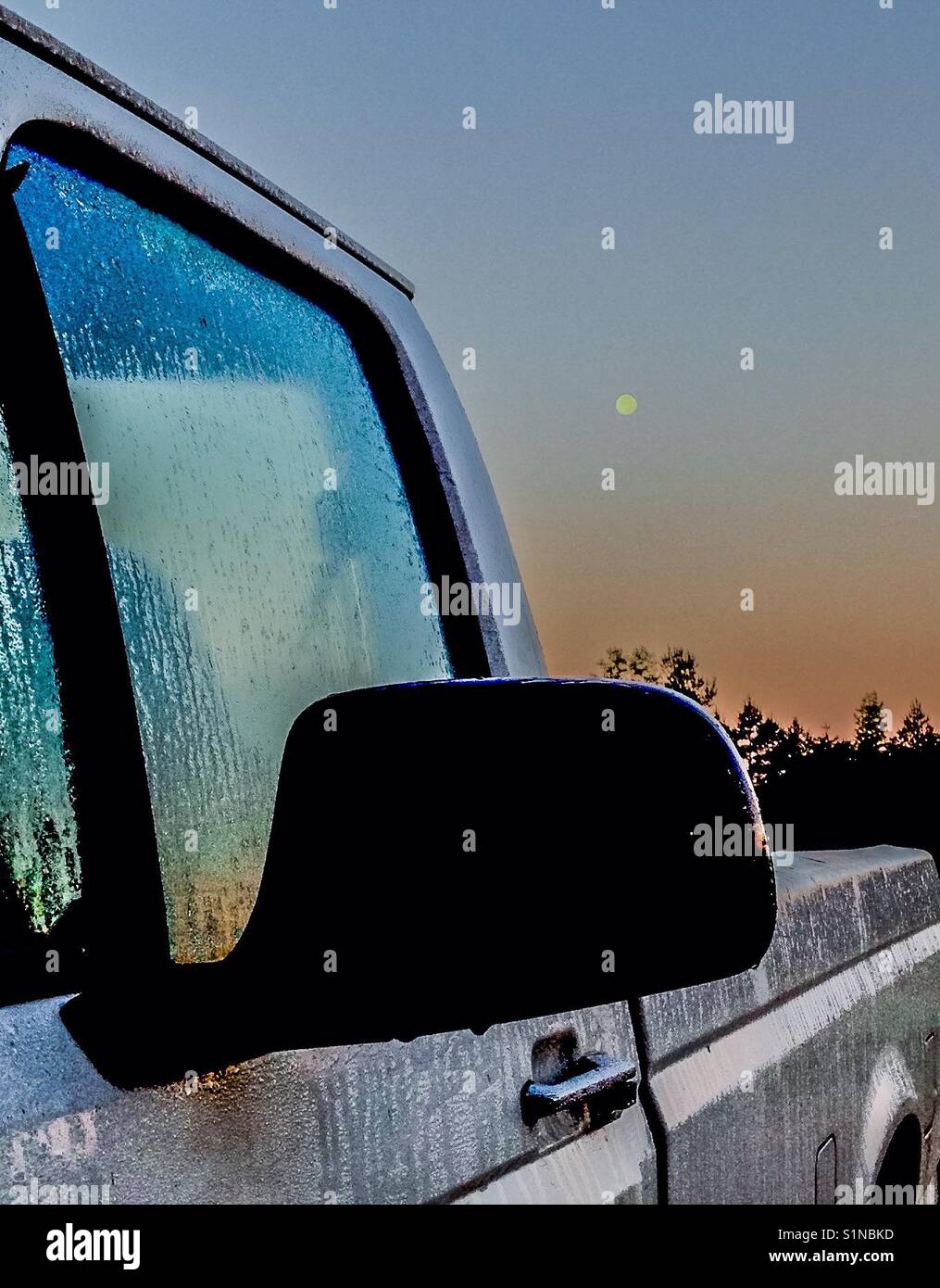 White pickup frames full morning moon in North Carolina field Stock Photo