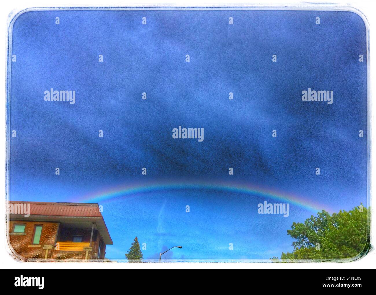 A rainbow bridge connecting us to nature. Stock Photo