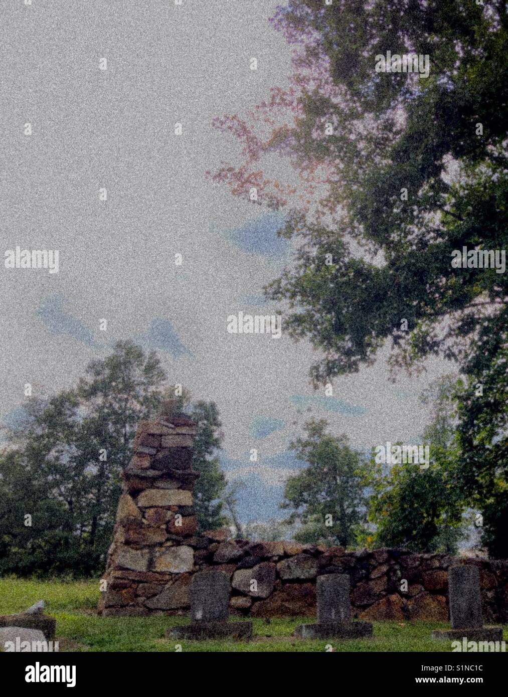 Somber photo of cemetery with cloudy sky, stone wall, and headstones - Smartphone Captured Stock Image