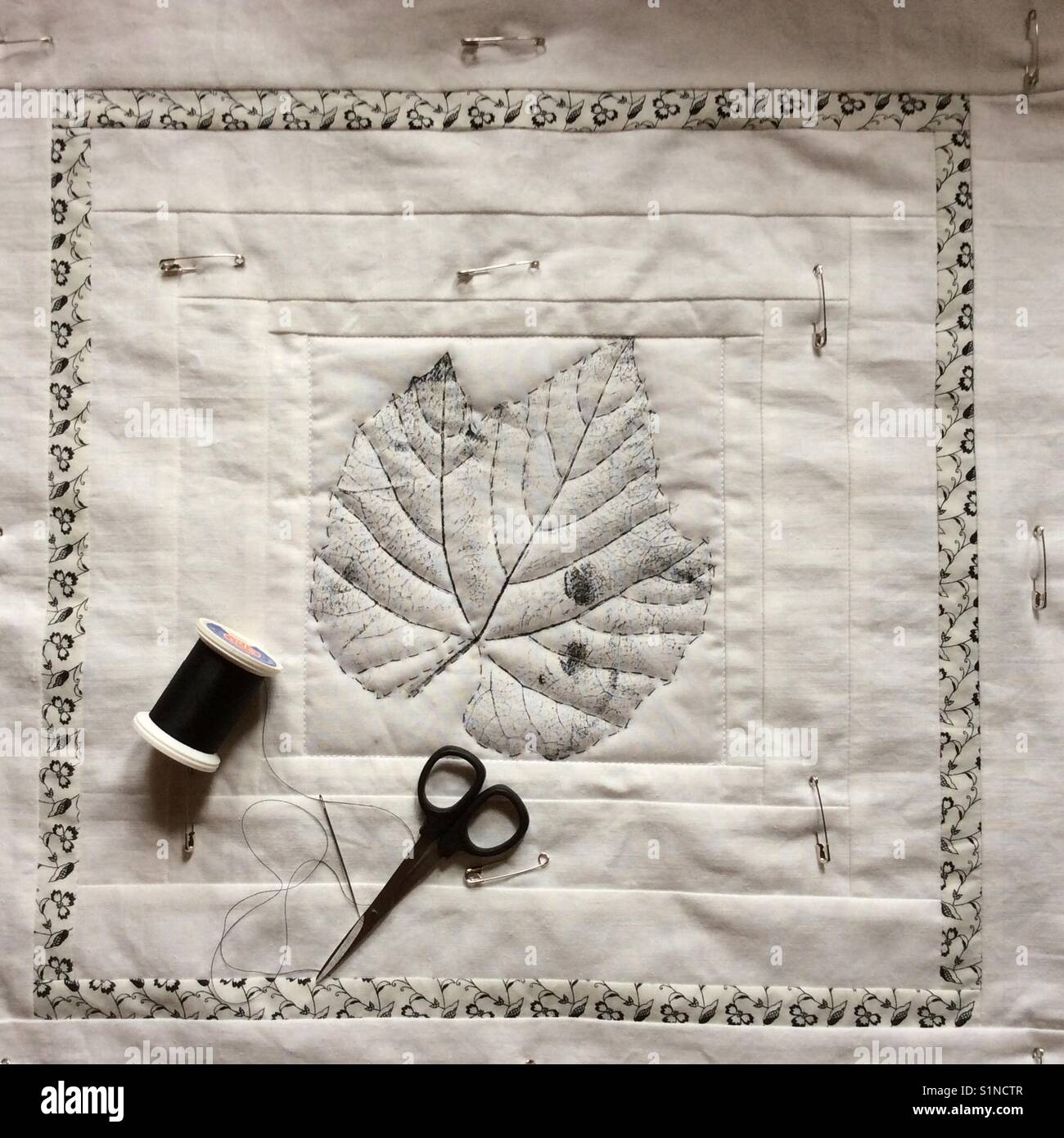 Working on an unfinished quilt with safety pins. Elevated view on the