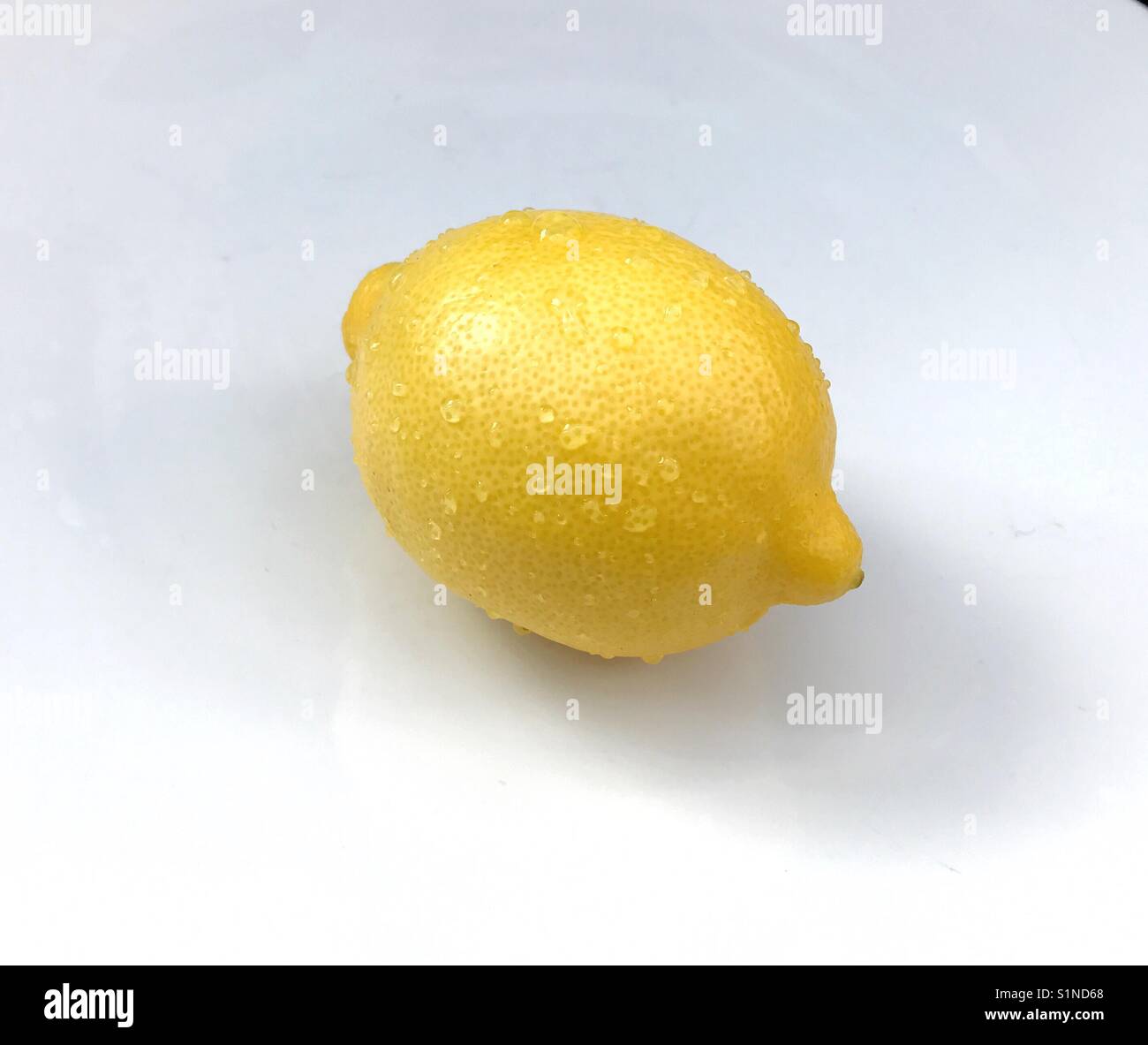 Lemon with droplets of water against a white background - Smartphone Captured Stock Image