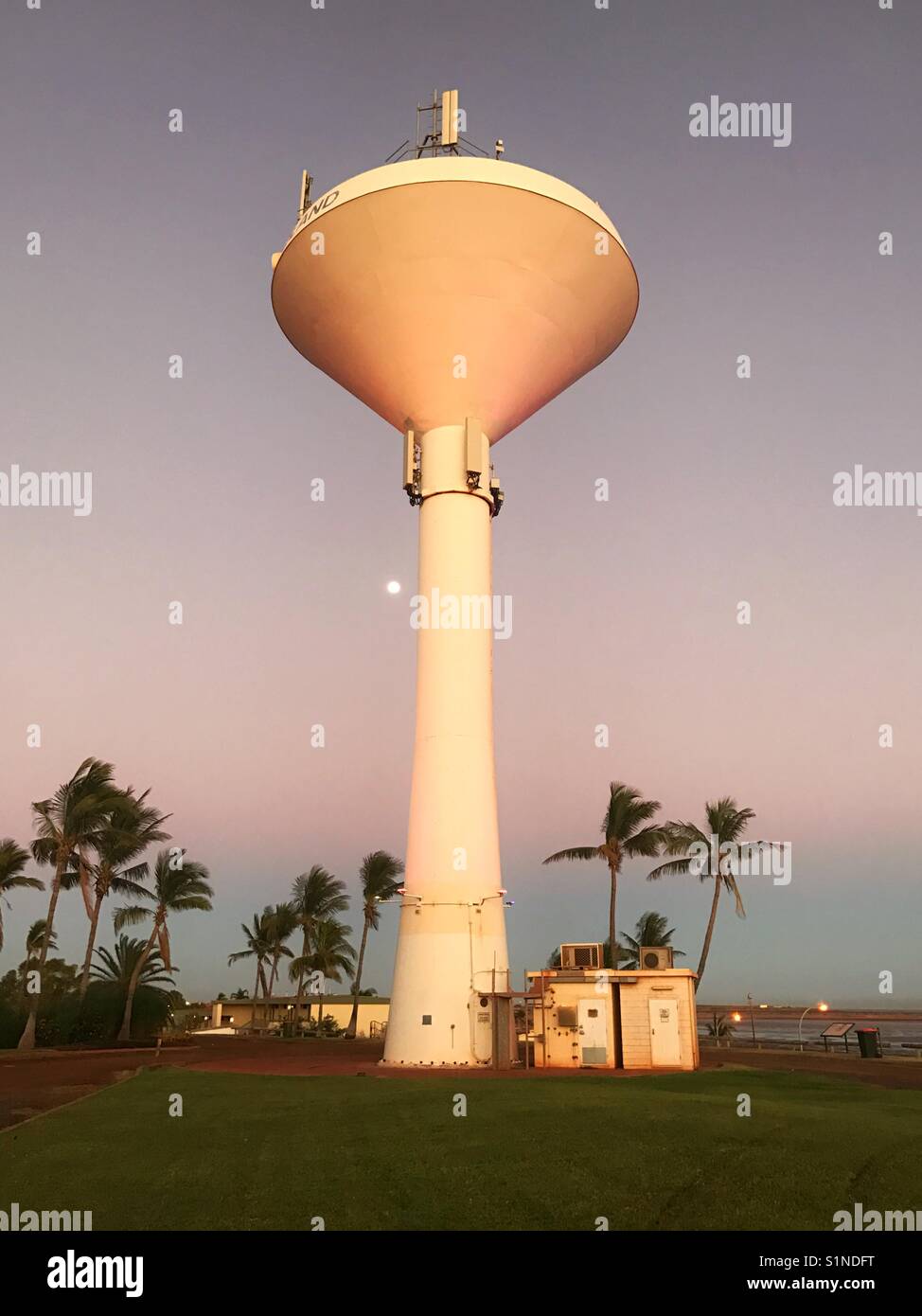Moon rising next to water tower - Smartphone Captured Stock Image