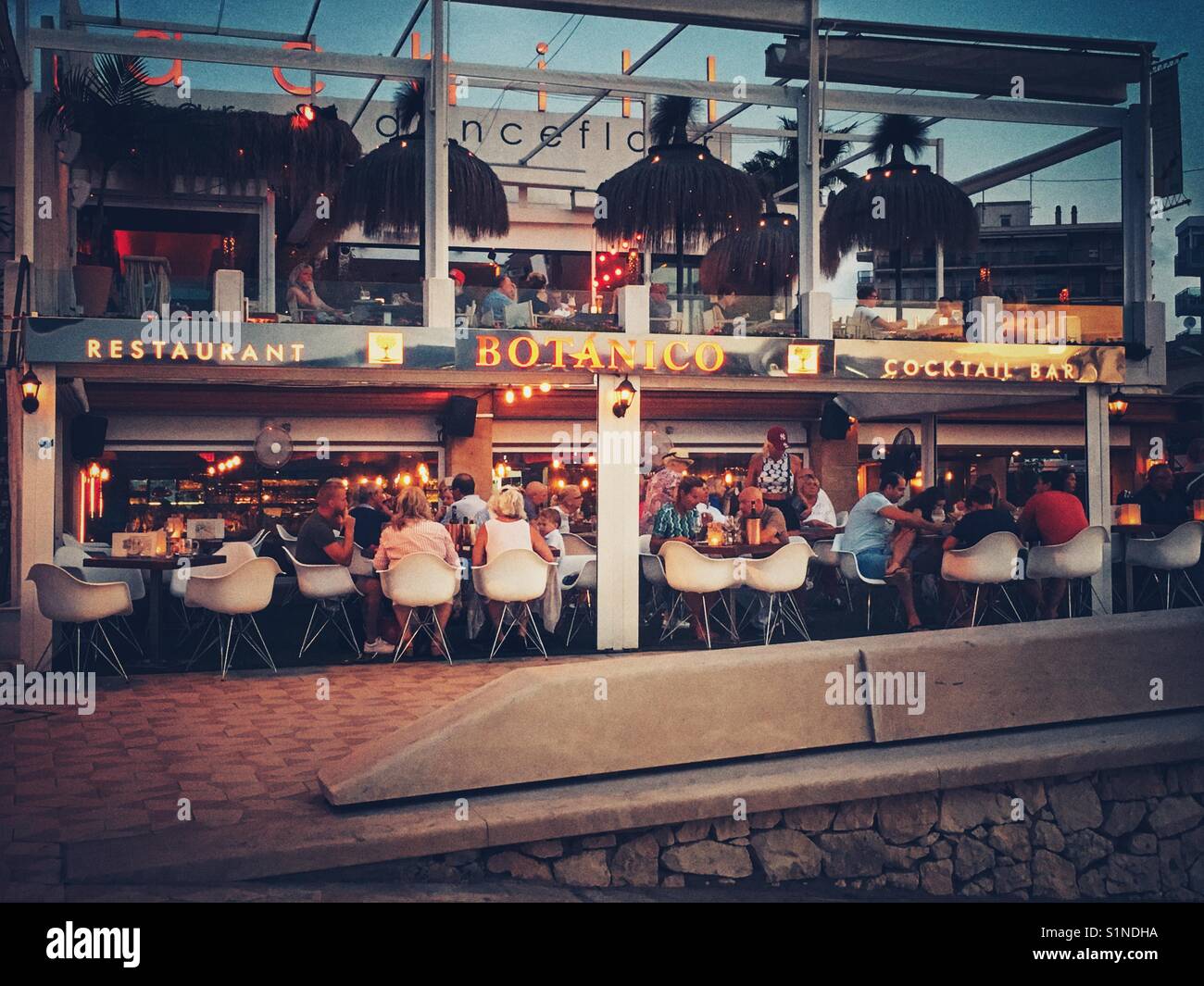 Restaurant Botanico Cocktail Bar on the Arenal beach, Javea, Spain. Diners in the restaurant at night in the summer - Smartphone Captured Stock Image