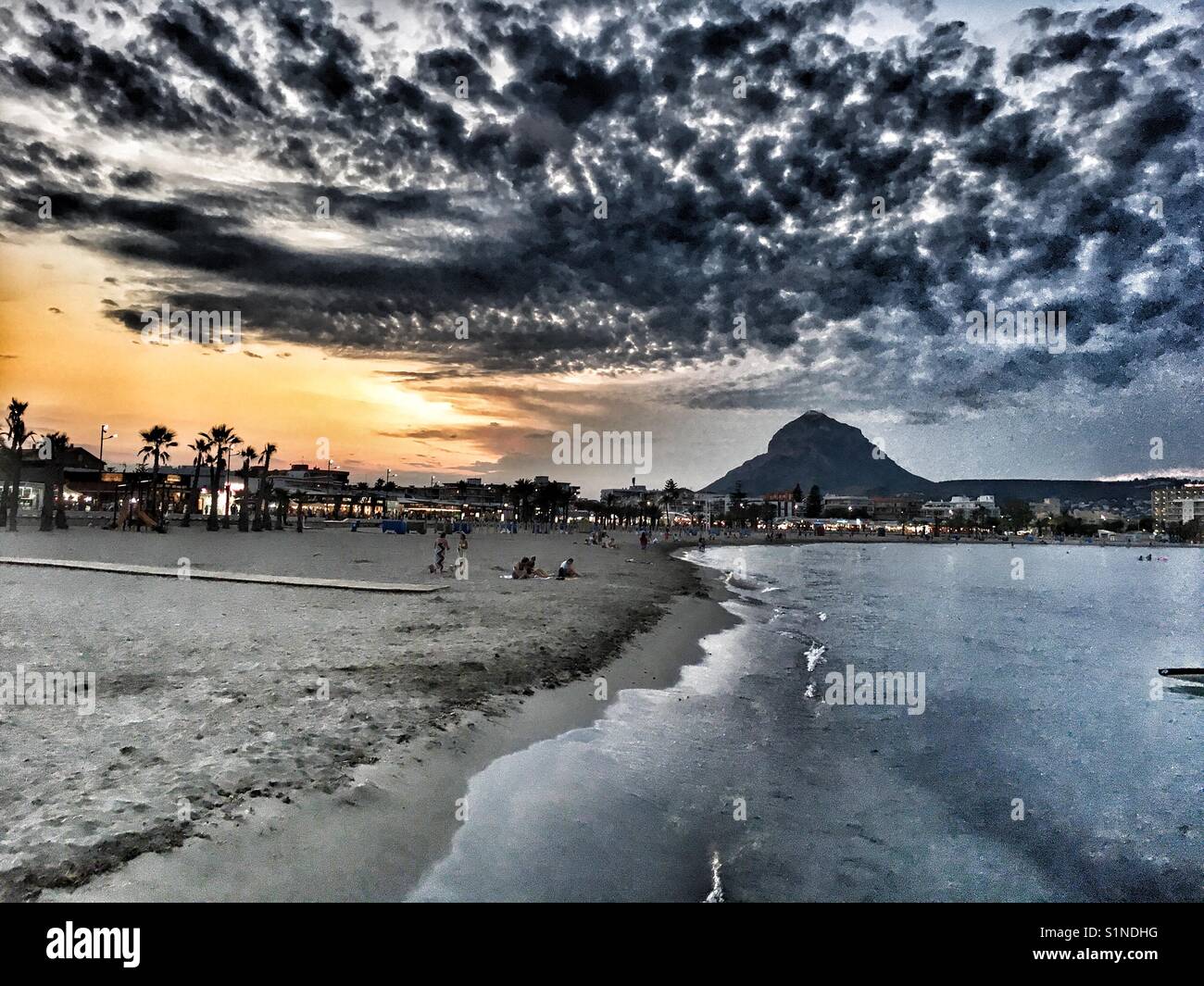 Sunset over the Arenal beach with Montgo mountain behind,  in Javea on the Costa Blanca, Spain - Smartphone Captured Stock Image
