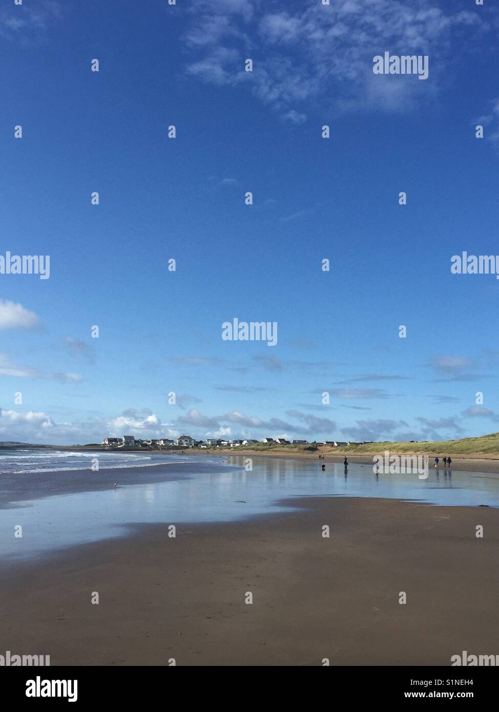 Walkers late afternoon in September on Broad Beach, Rhosneigr, Anglesey, North Wales - Smartphone Captured Stock Image