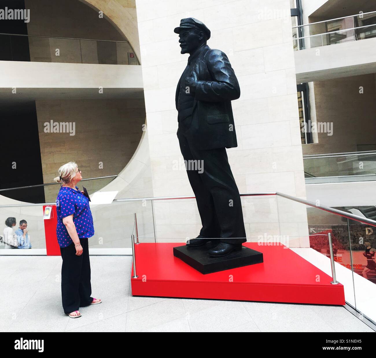 Woman looks up at Lenin statue - Smartphone Captured Stock Image