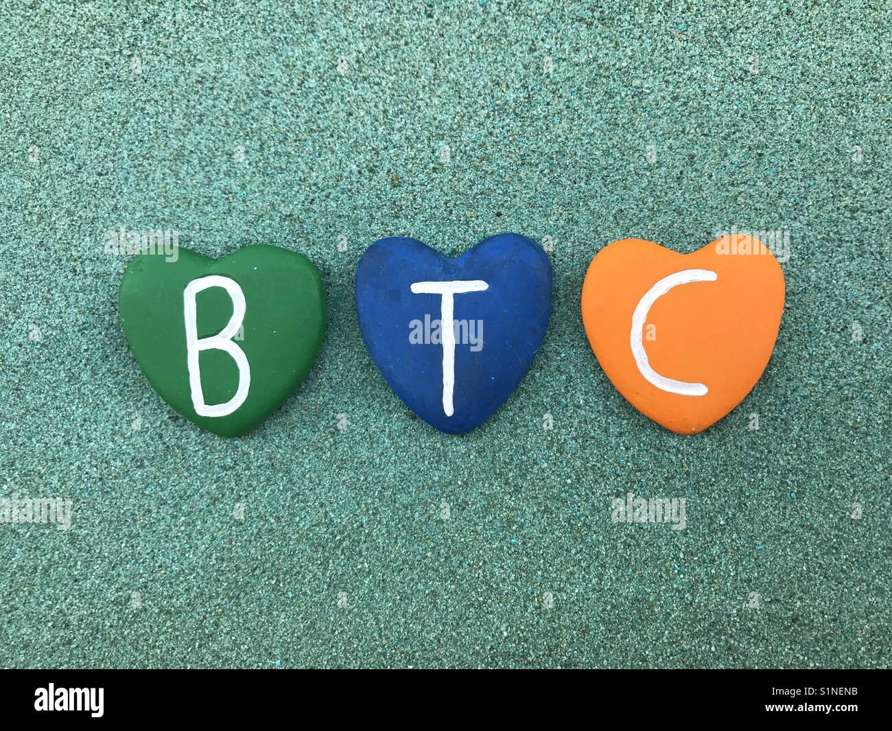 BTC, Bitcoin, worldwide cryptocurrency and digital payment system with colored heart stones Stock Photo