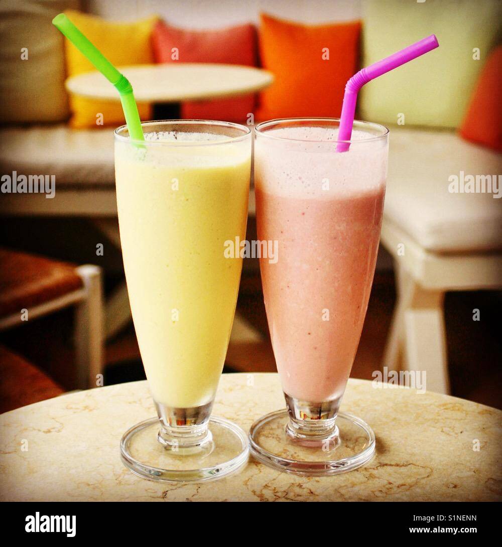 Two glasses of smoothie on a table in an empty cafe - Smartphone Captured Stock Image