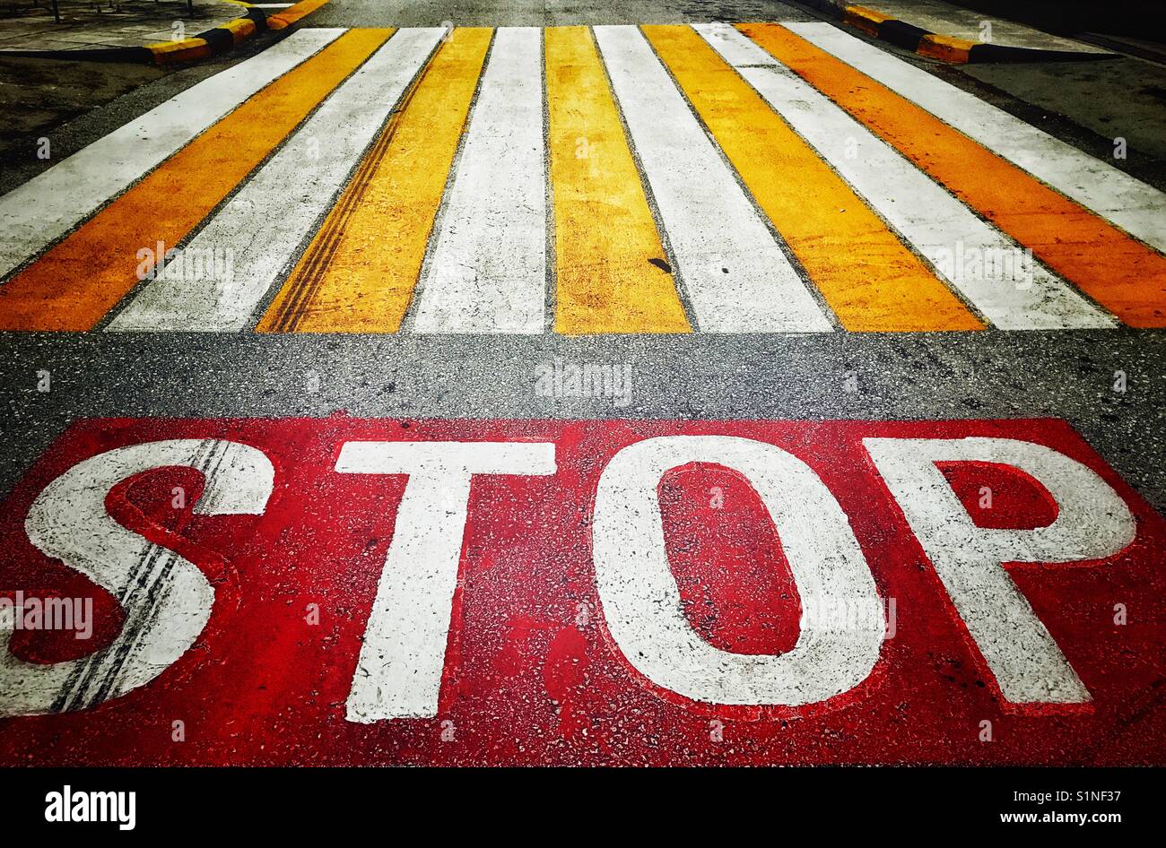 Red Stop signage and yellow zebra crossing Stock Photo Alamy