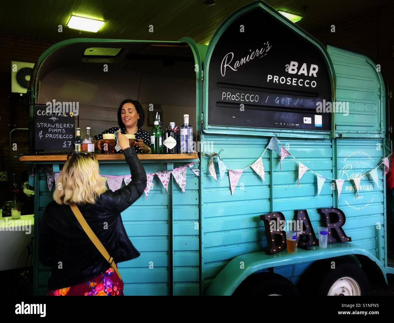 Woman buying a drink from Prosecco van - Smartphone Captured Stock Image