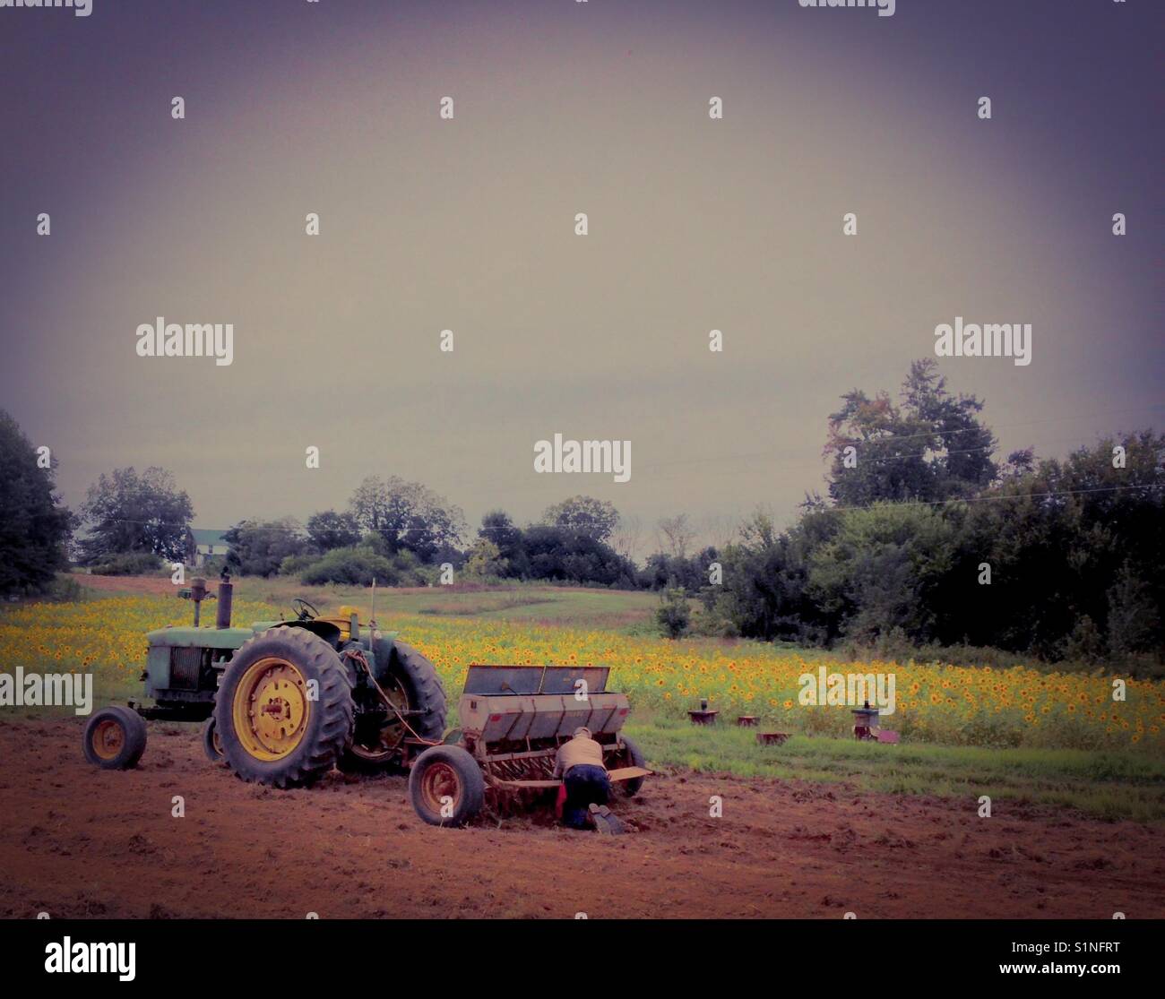 Farmer working on drill so he can plant clover for spring - Smartphone Captured Stock Image