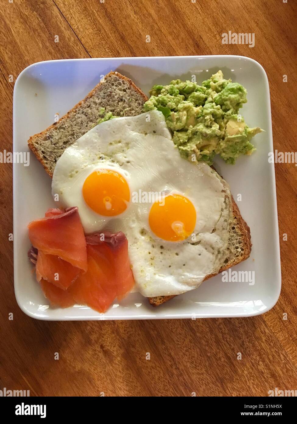 Fried eggs on homemade multi grain bread with avocado and salmon - Smartphone Captured Stock Image