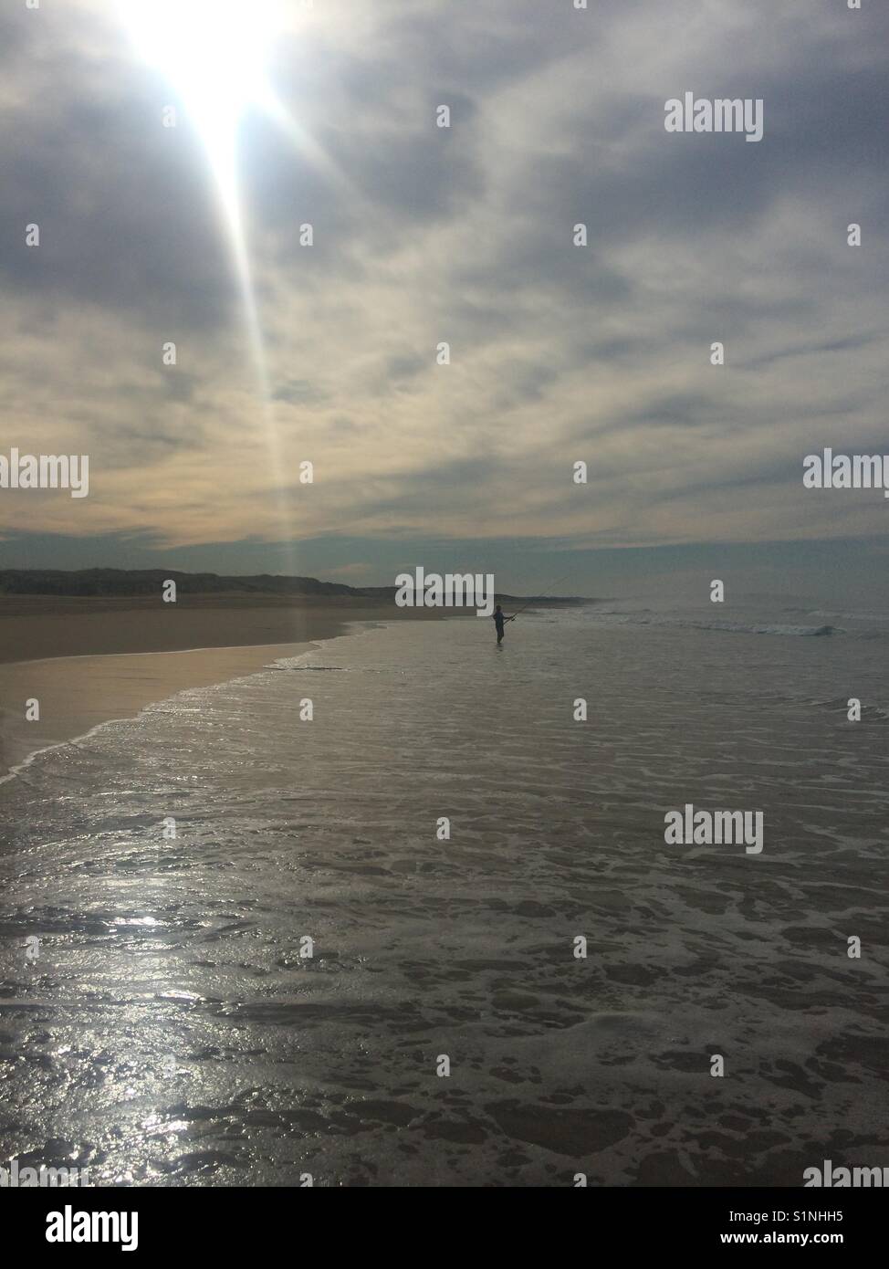 Lone fisherman on sunny beach - Smartphone Captured Stock Image