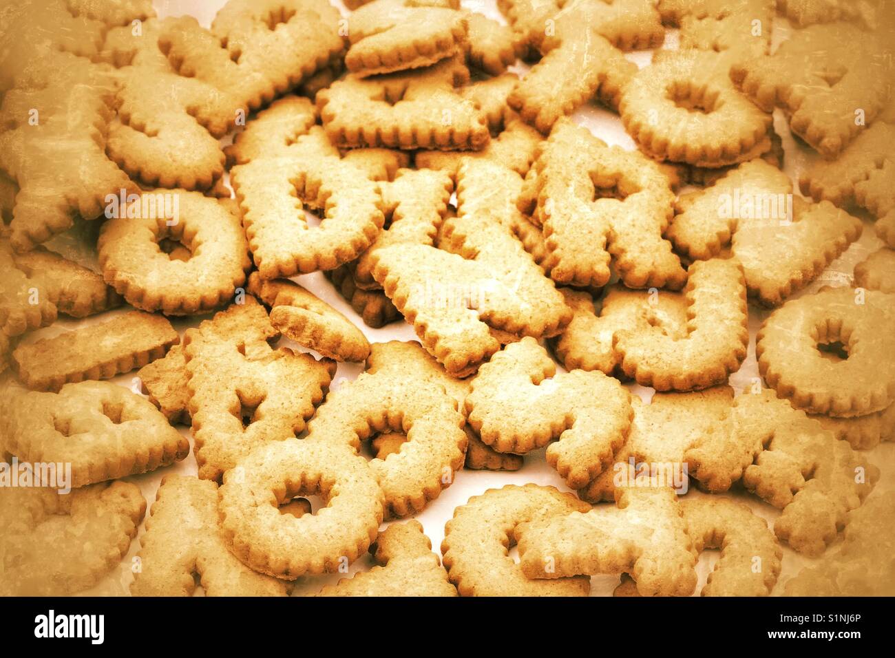 A full frame image of alphabet shaped cookies and letters piled up on top of each other. - Smartphone Captured Stock Image
