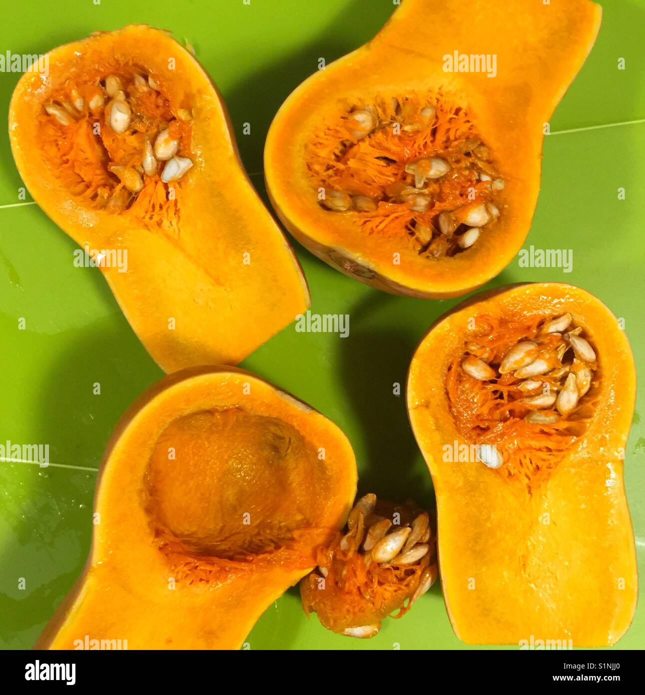 Fresh Honey Nut Squash, 4 halves (3 with seeds, 1 scooped), with honey colored flesh Stock Photo