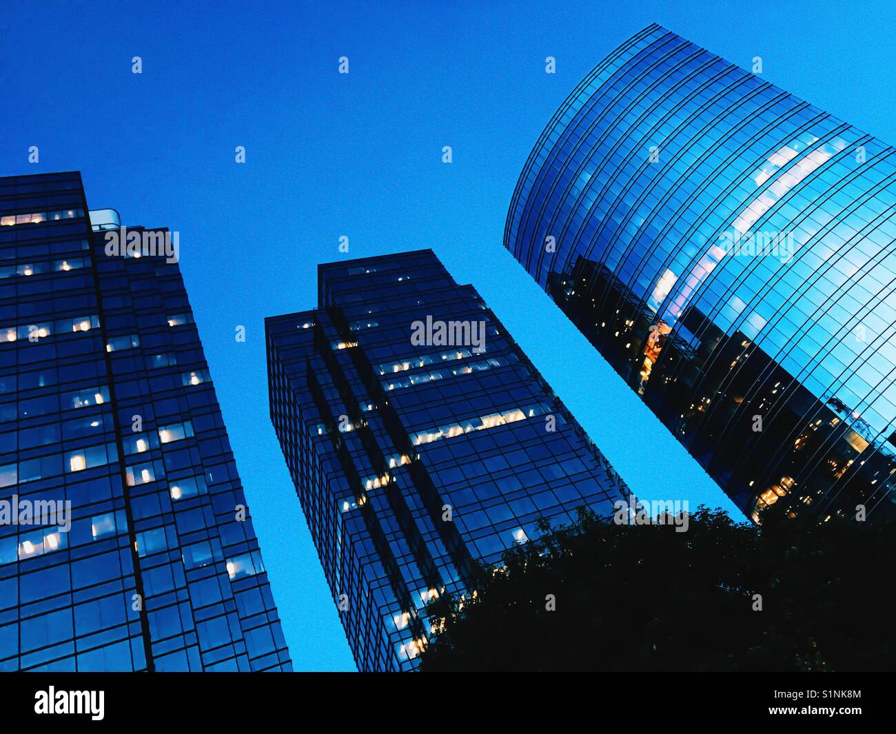 Urban landscape. Looking up at three tall office buildings just after sunset in the Metrotown area of Burnaby, BC on a late August evening. - Smartphone Captured Stock Image