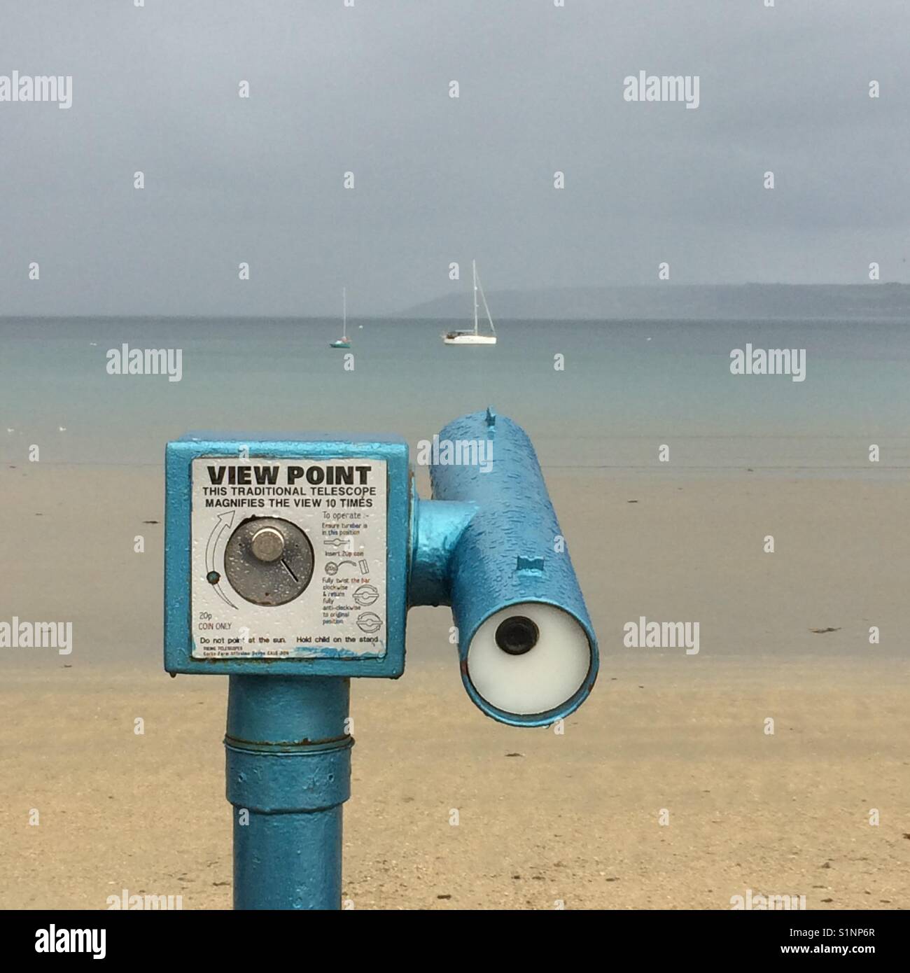 A telescope points seaward to a couple of moored yachts in Mounts Bay, Cornwall - Smartphone Captured Stock Image