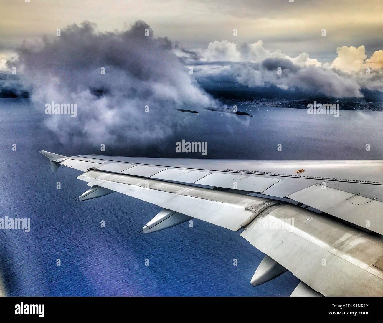 View from plane of clouds and ocean. Stock Photo