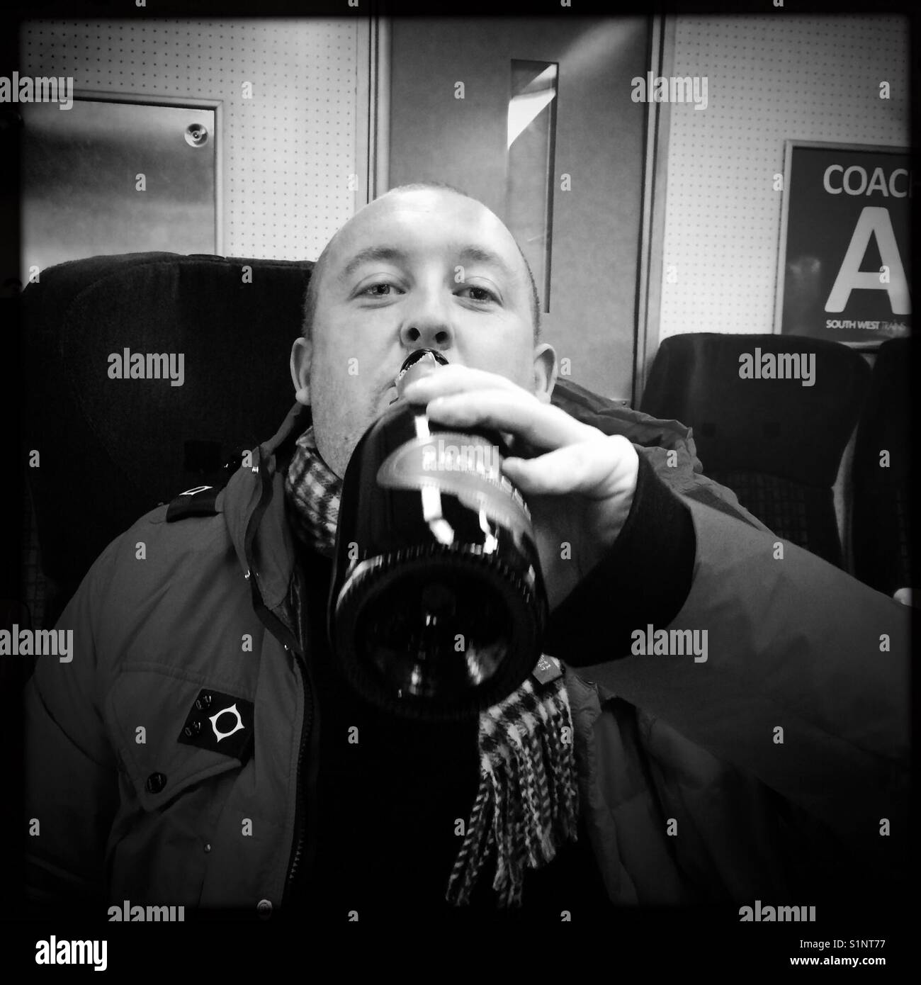 Man drinking bottle of Prosecco on train - Smartphone Captured Stock Image