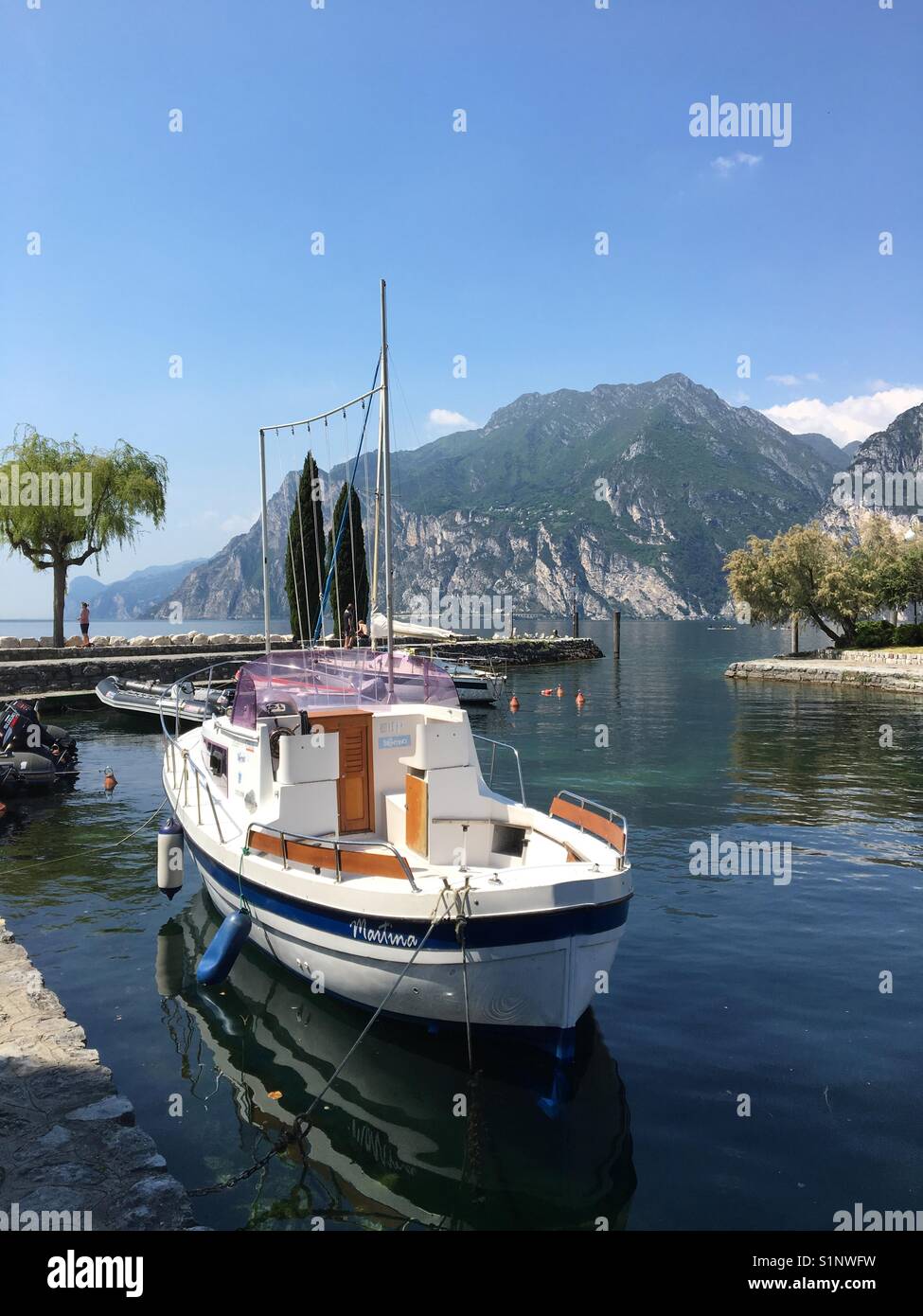 Small boat moored in the harbour of Torbole on Lake Garda Stock Photo