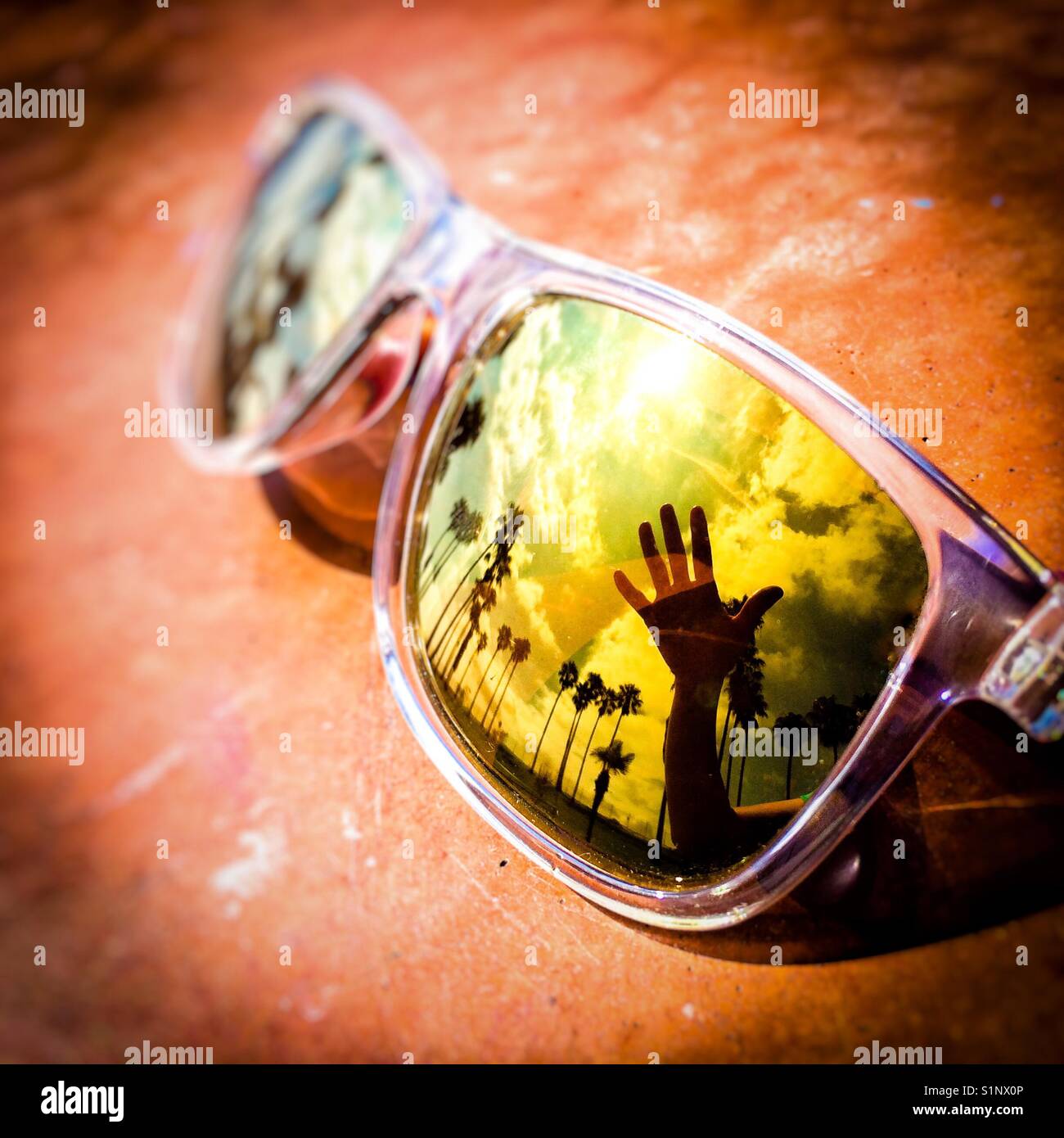 Opened hand and plams tree reflection on sunglasses near Los Angeles international airport, USA - Smartphone Captured Stock Image