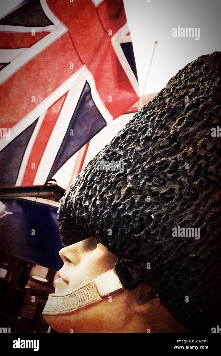 A British Buckingham Palace guard figure in front of Union Jack Stock Photo