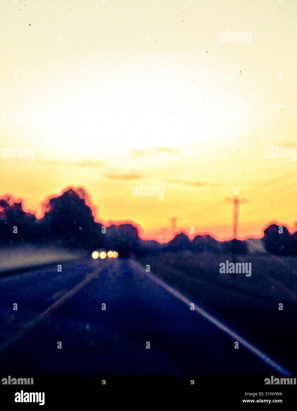 Through the windshield, down the road, into the sunrise - Smartphone Captured Stock Image