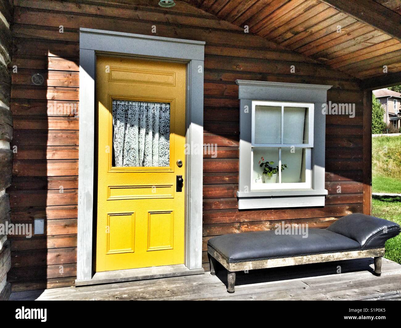Bright yellow door of a wooden cabin. - Smartphone Captured Stock Image