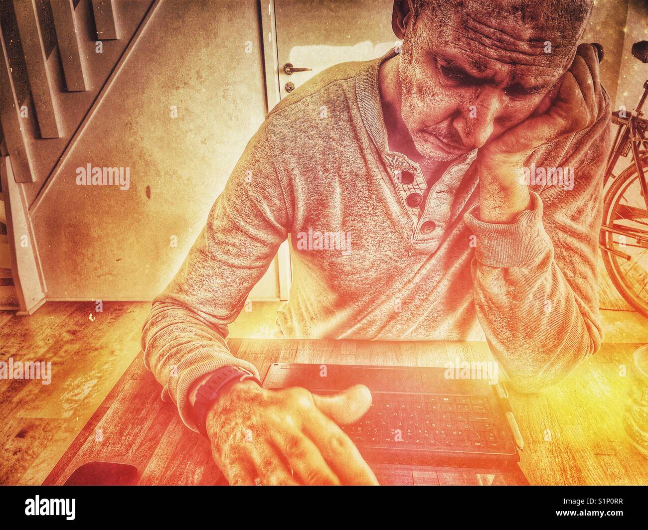 Bored serious middle aged Scandinavian man working on laptop at home - Smartphone Captured Stock Image