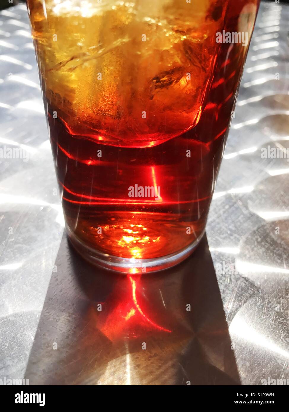 Glass of vermouth and its reflection on metallic surface. - Smartphone Captured Stock Image