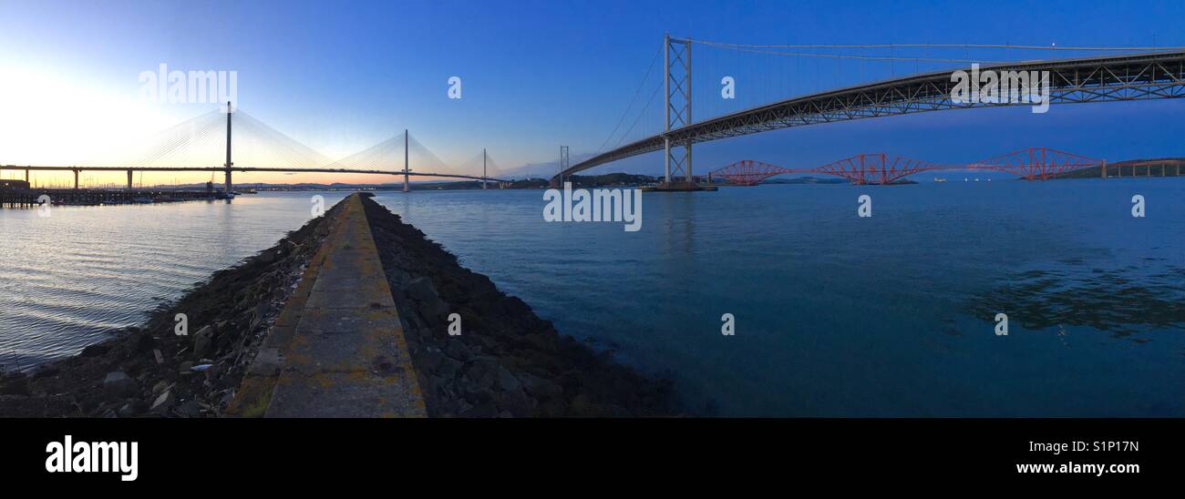Evening view of the three major bridges crossing the River Forth in Scotland, United Kingdom. New Queensferry Crossing is on the left. Stock Photo