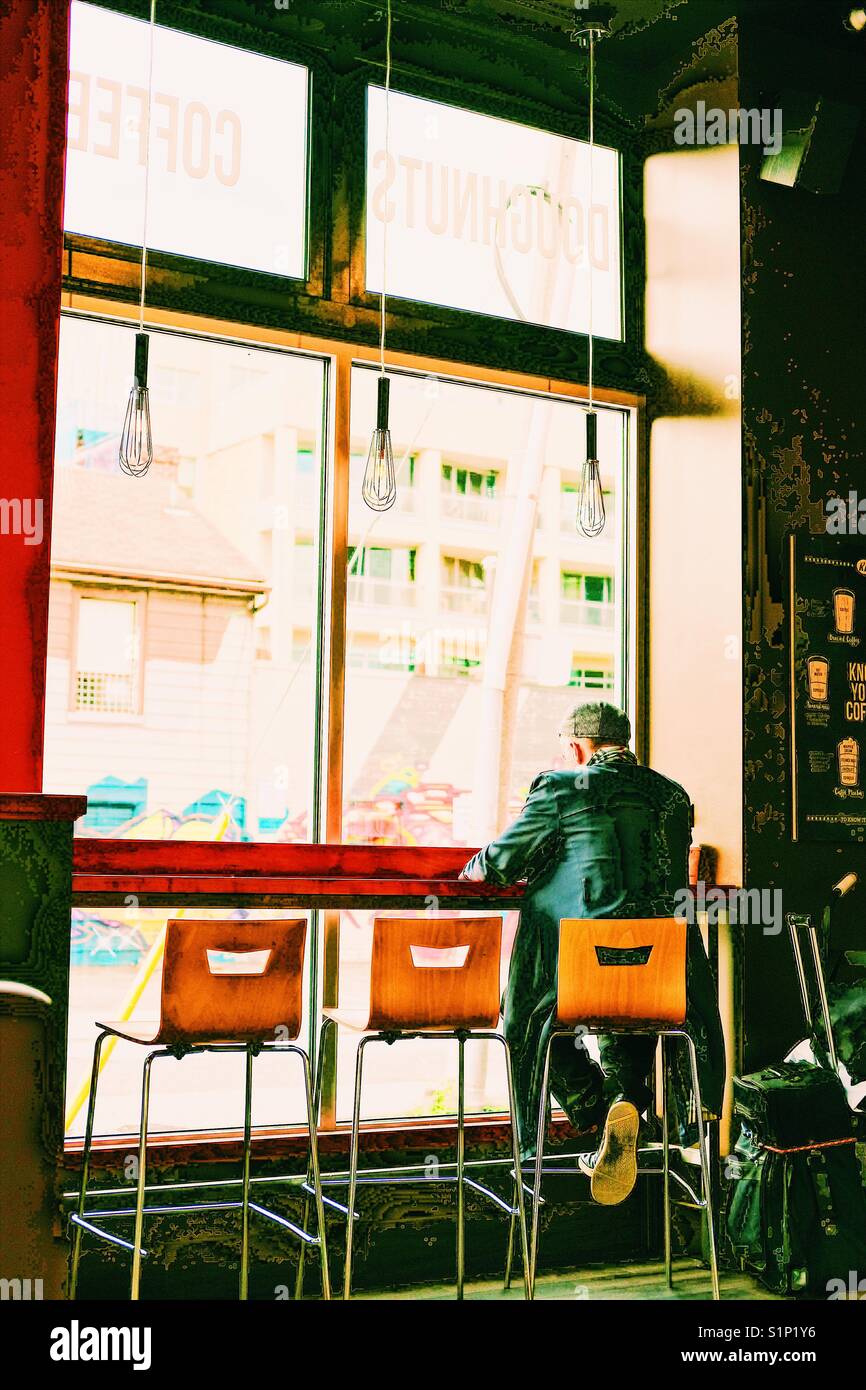Rear view of man sitting alone in cafe, Toronto, Canada - Smartphone Captured Stock Image