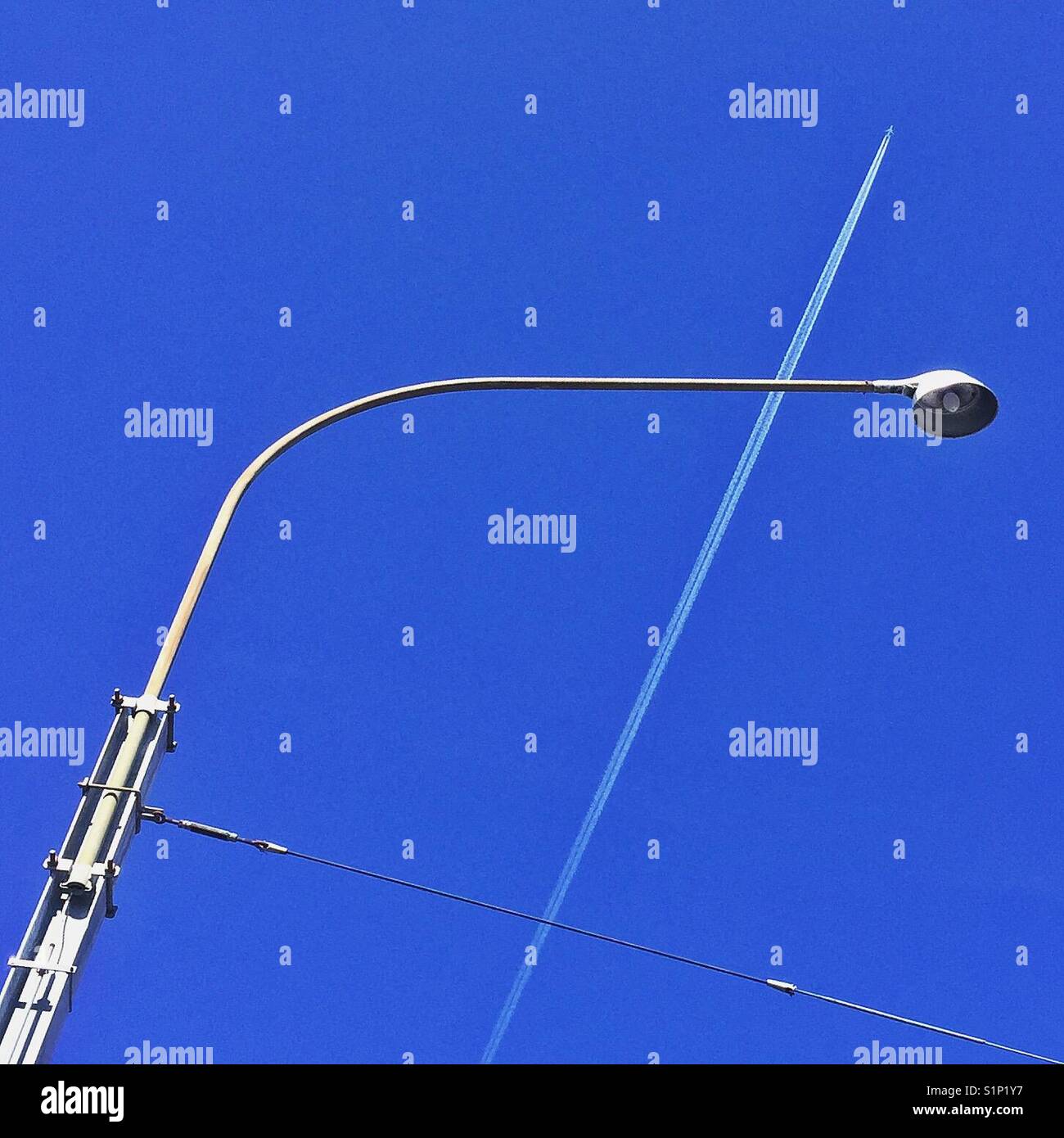 To infinity and beyond - lamppost and plane with vapour trail - Smartphone Captured Stock Image