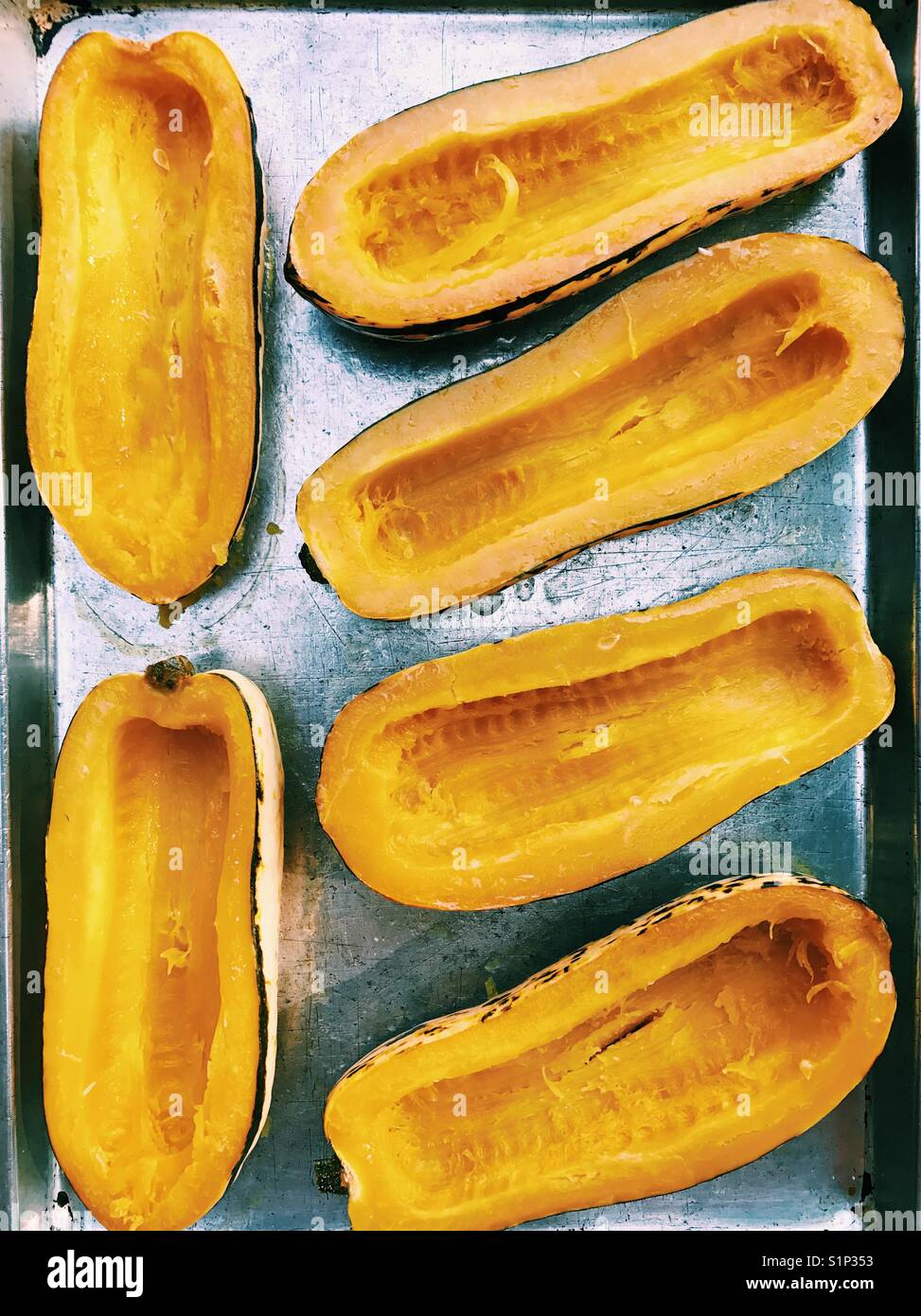 A tray of roasted delicata squash halves. Stock Photo