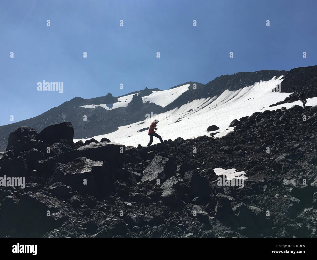 Hiking past the melting snow on the lava covered slopes of Mount Bachelor in The Pacific Northwest near Bend Oregon. - Smartphone Captured Stock Image