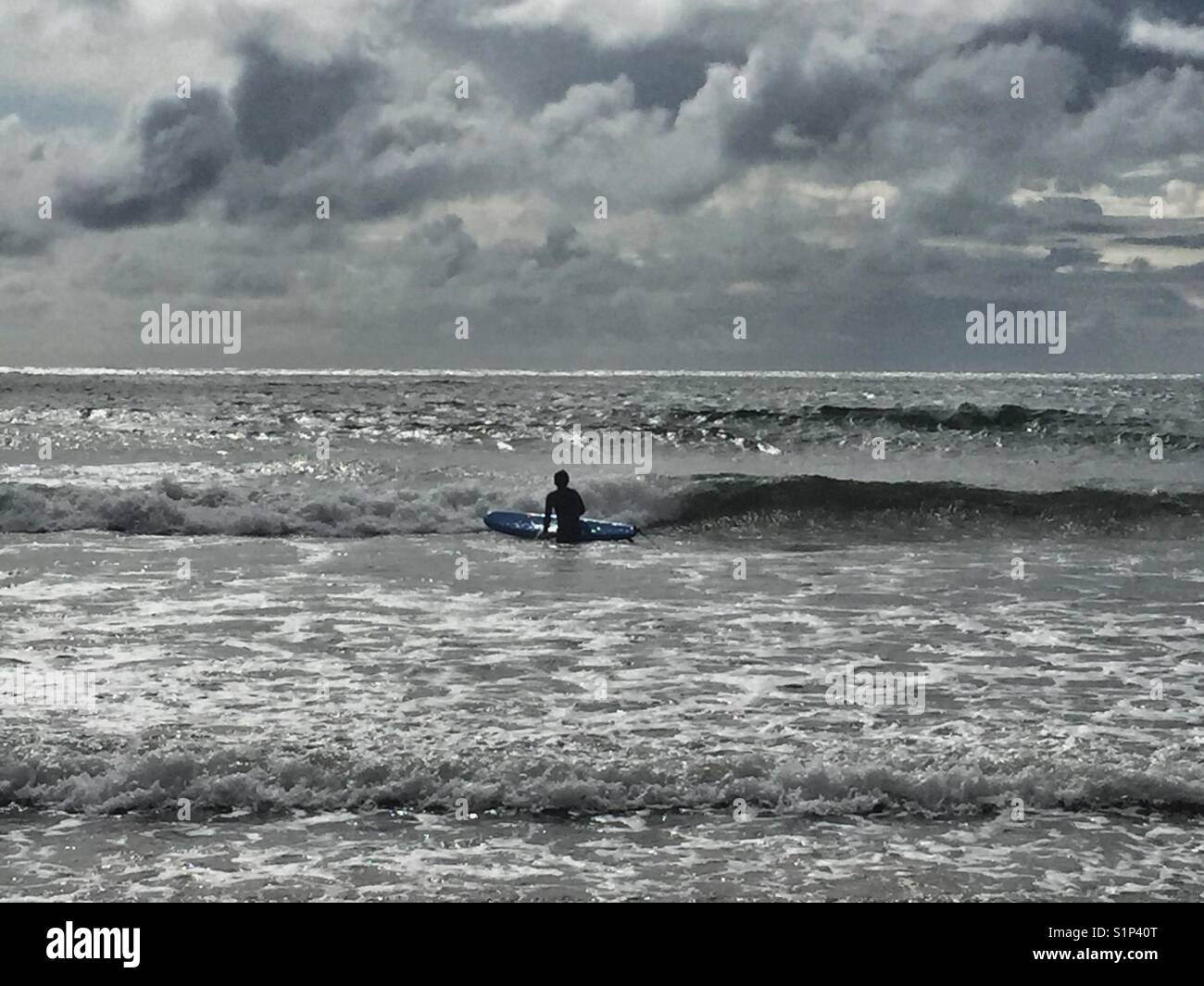 Surfer in the waves at Broad Beach, Rhosneigr, Anglesey, North Wales. - Smartphone Captured Stock Image