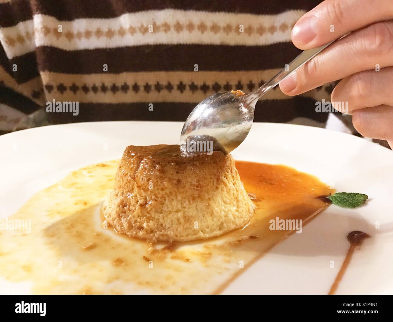 Man having creme caramel. - Smartphone Captured Stock Image