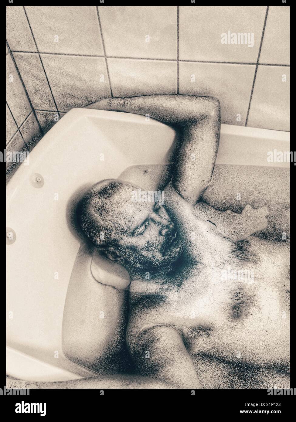 Middle aged Scandinavian man asleep in the bath Stock Photo