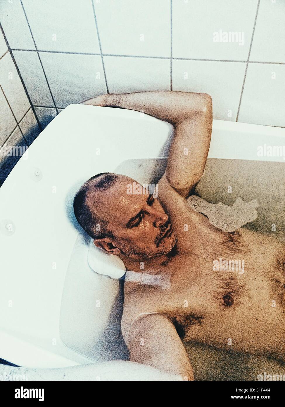 Middle aged Scandinavian man asleep in the bath - Smartphone Captured Stock Image